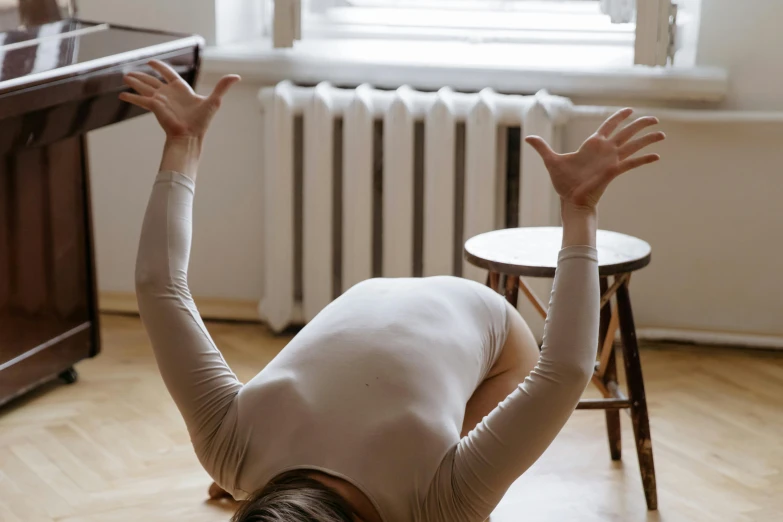 a woman stretching with her arms extended near an empty table