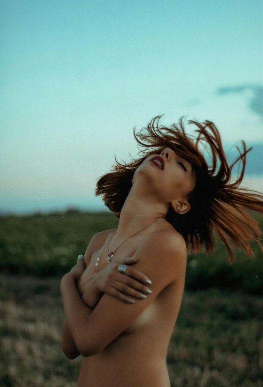 a woman with very long hair is posing on the beach