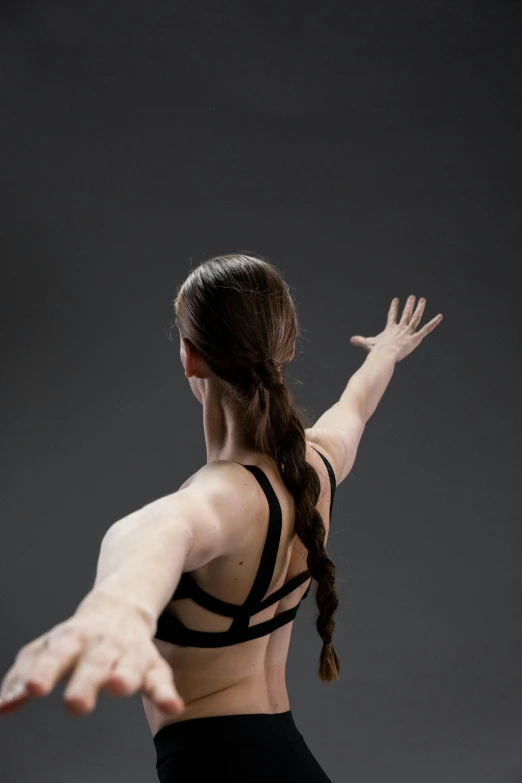 an asian girl wearing a sports  top is stretching her arms to the side