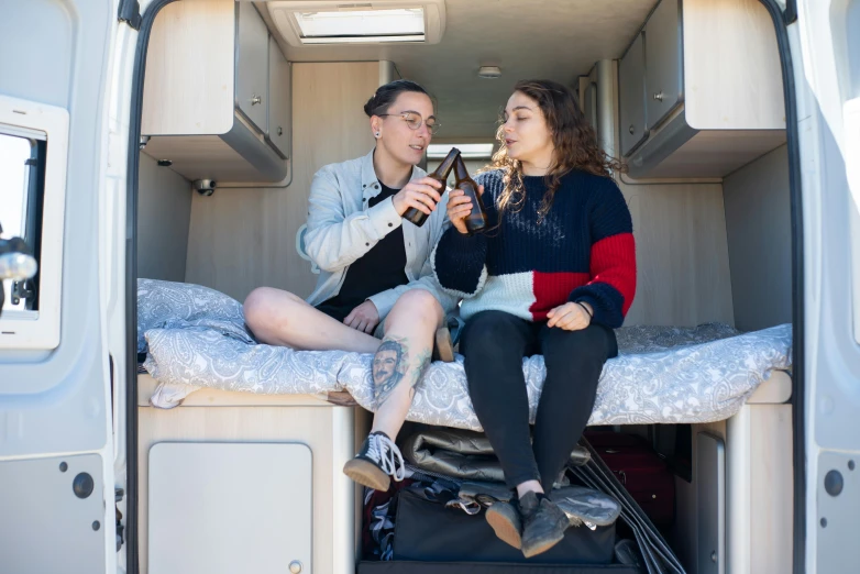 a man and woman sitting in the back of a van