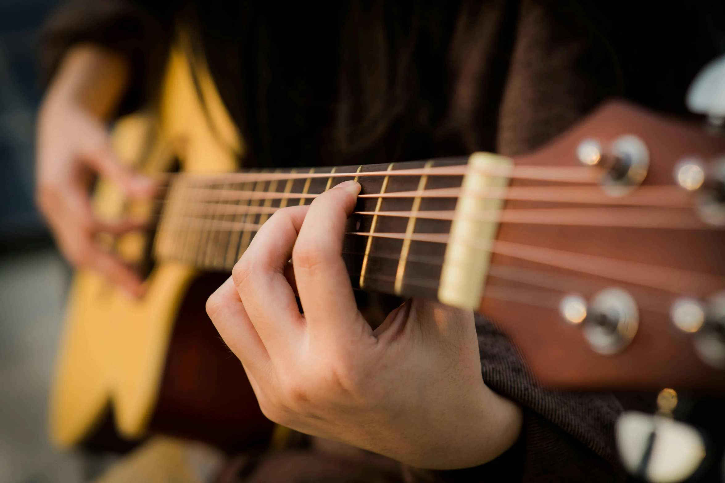 the fingers and strings of a person playing a guitar