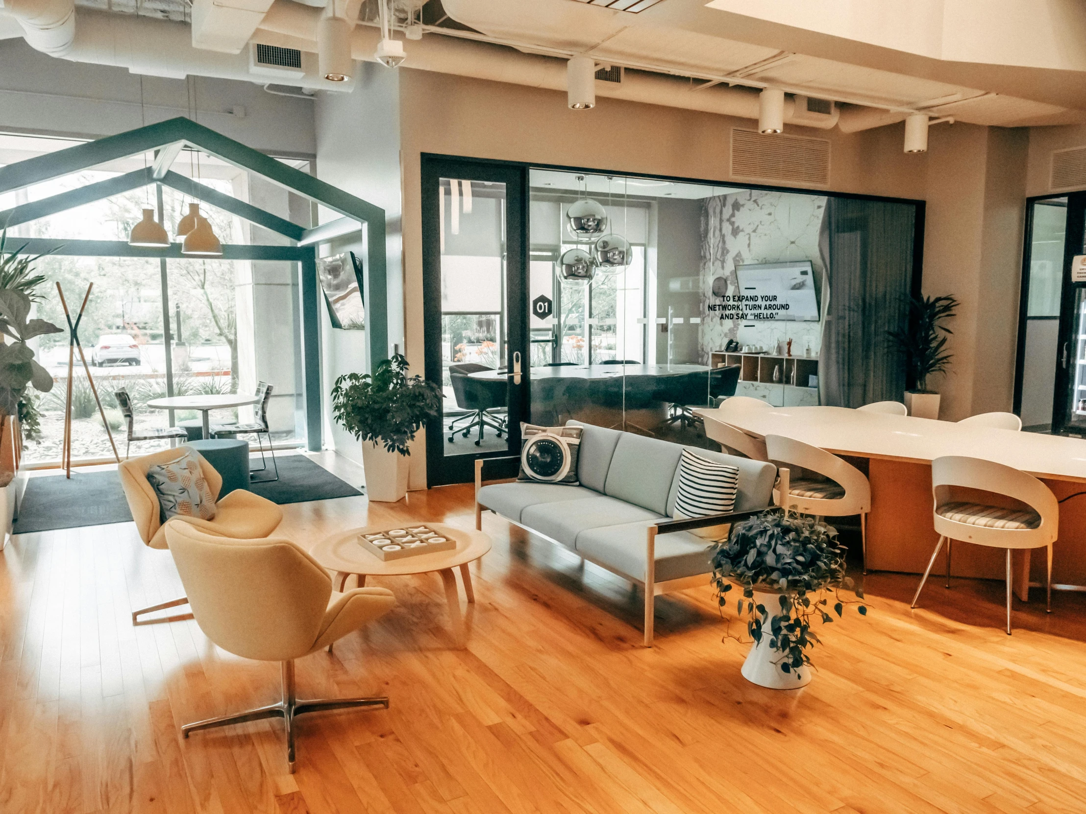 an open living room with hardwood floors, wood furniture, and an open kitchen