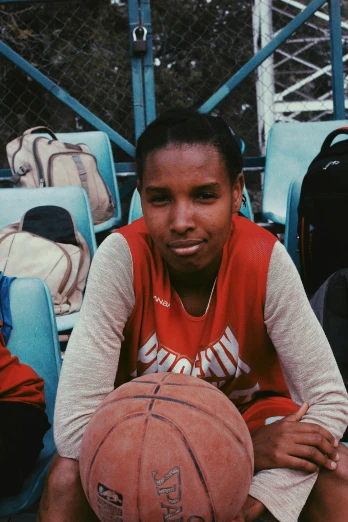a boy with a basketball and the stands next to him