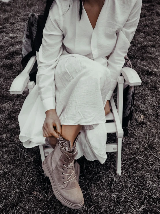 woman with boots sitting on folding chair outdoors