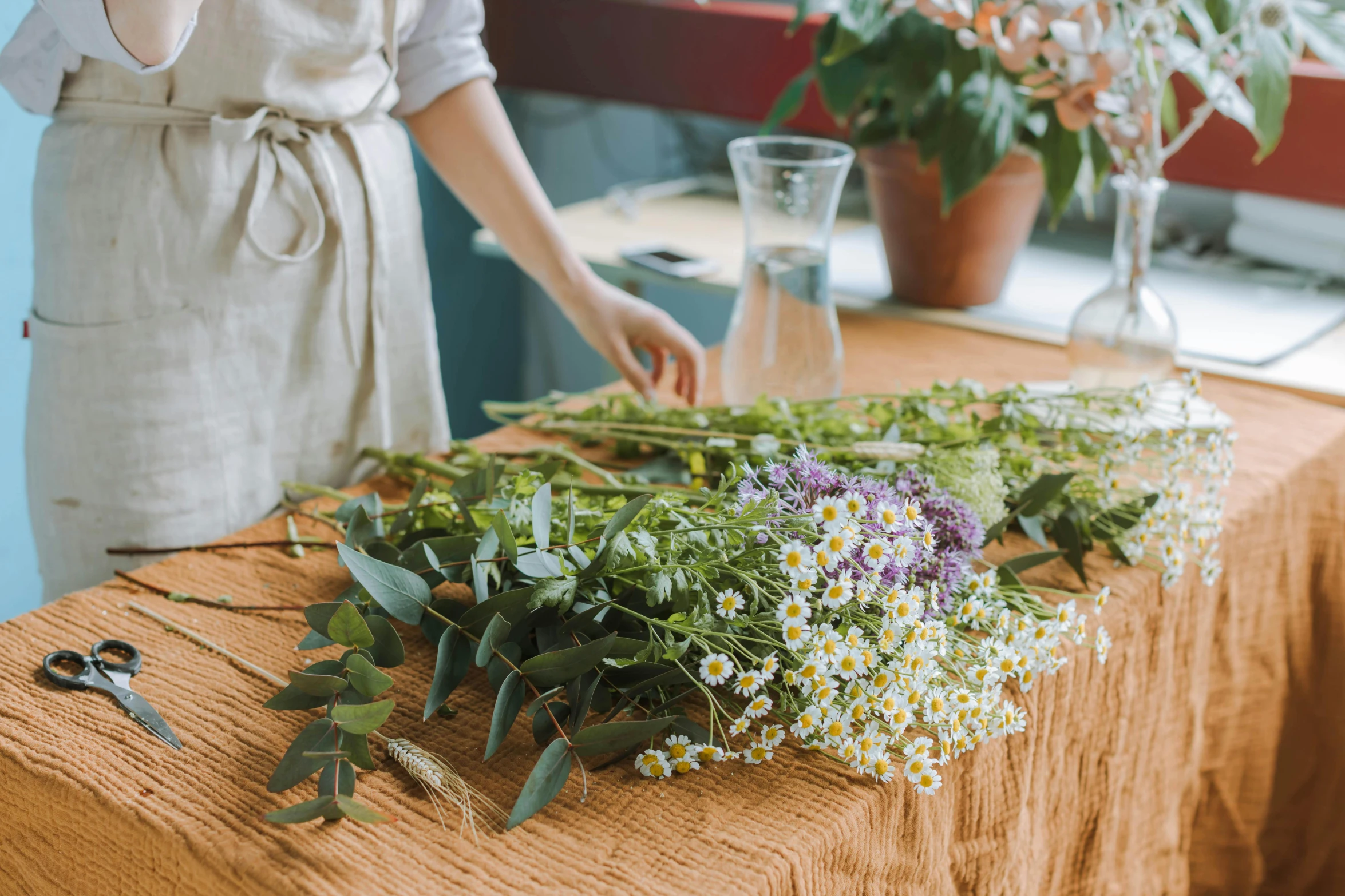 a woman in apron standing over an array of flowers