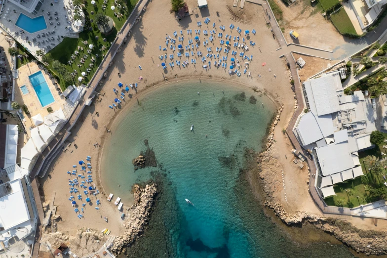 aerial view of an ocean beach and pool with umbrellas