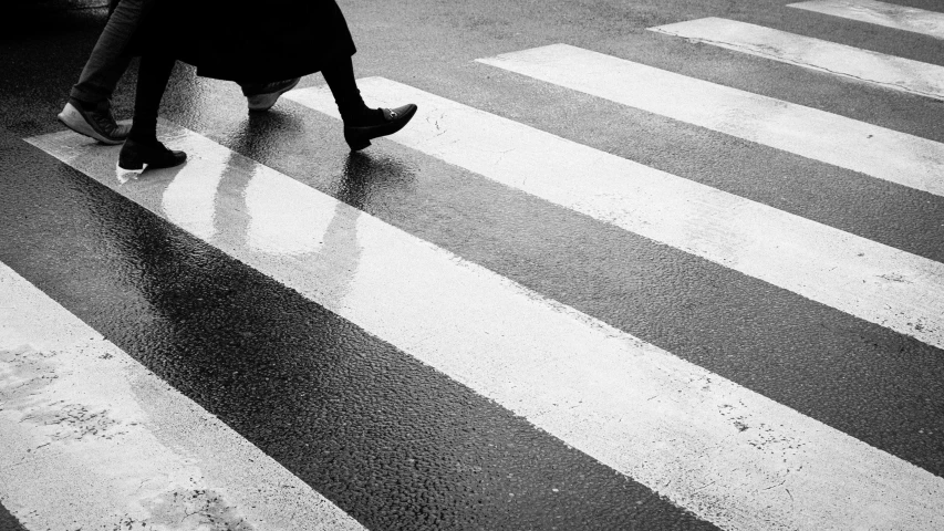 a black and white image of someone crossing the street