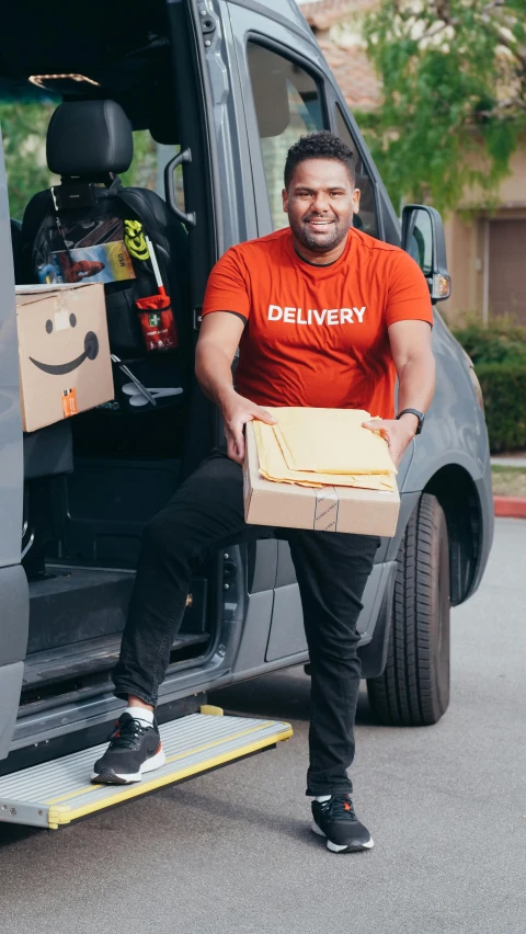 a man is getting out of his van with a box