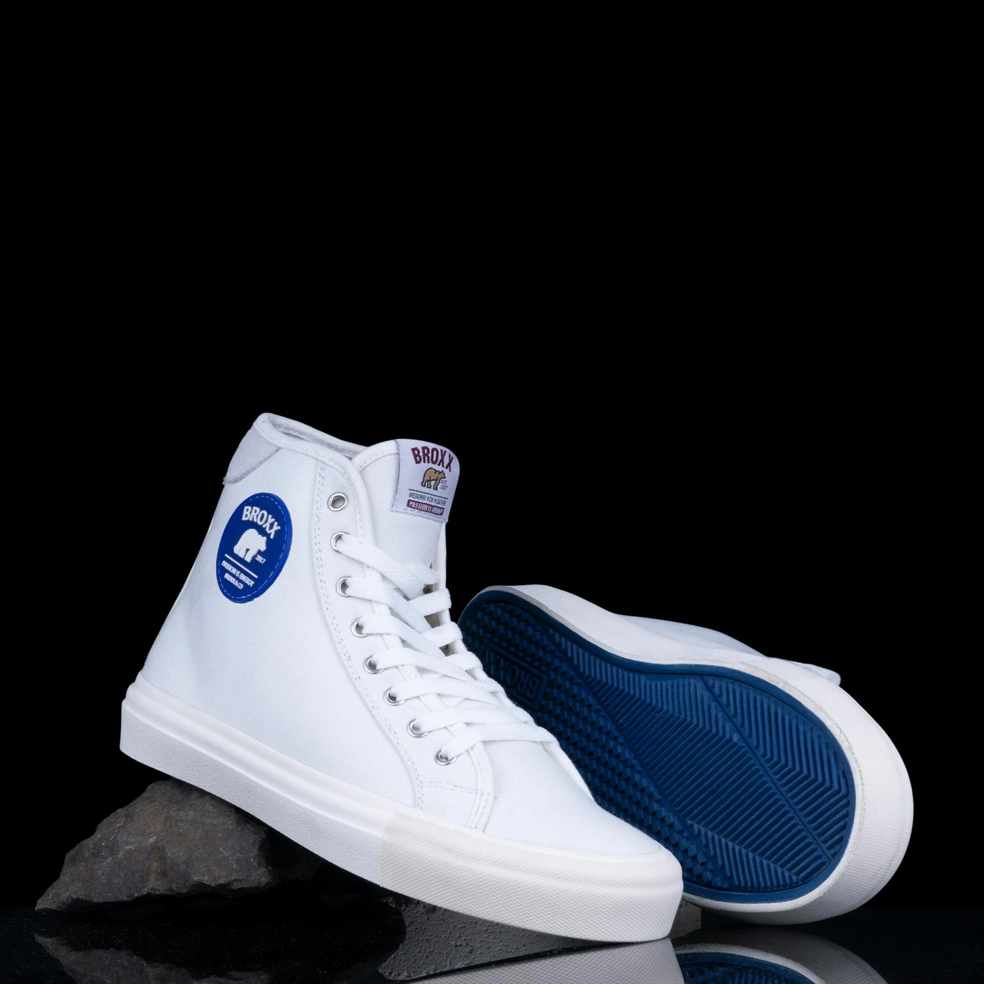 white and blue sneakers are on a black surface