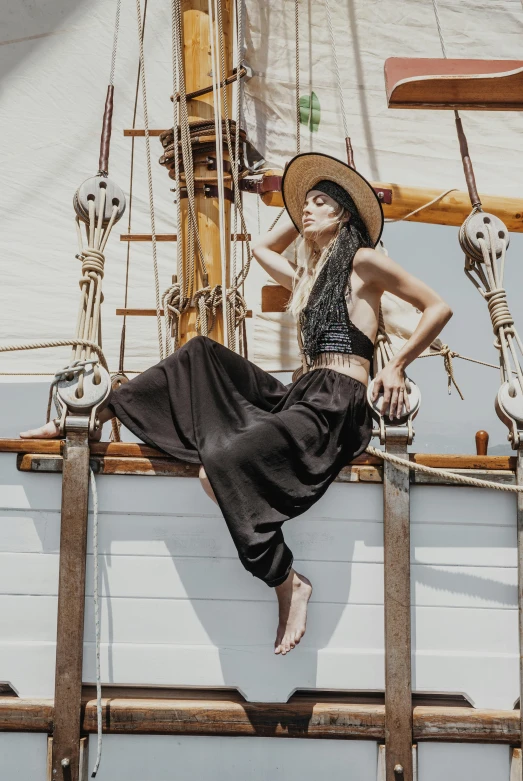 a woman posing for a po in front of a large sailboat