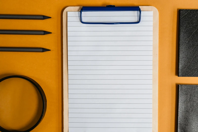 a note pad and various pens and magnets on a table