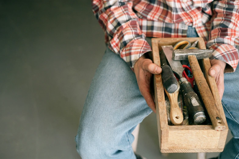 an open wooden box containing some assorted tools