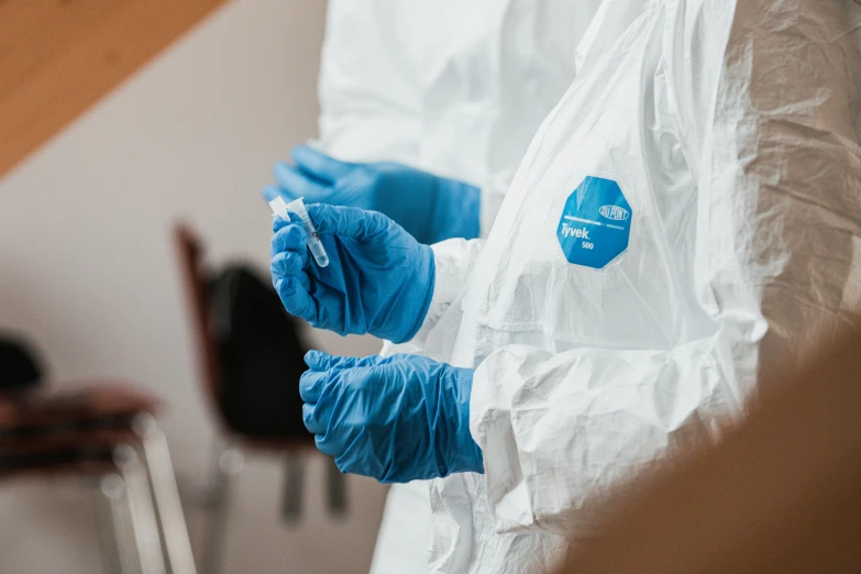 a person in white suit and blue gloves