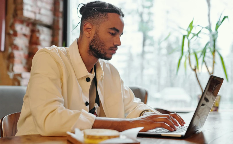 man at a restaurant using a laptop