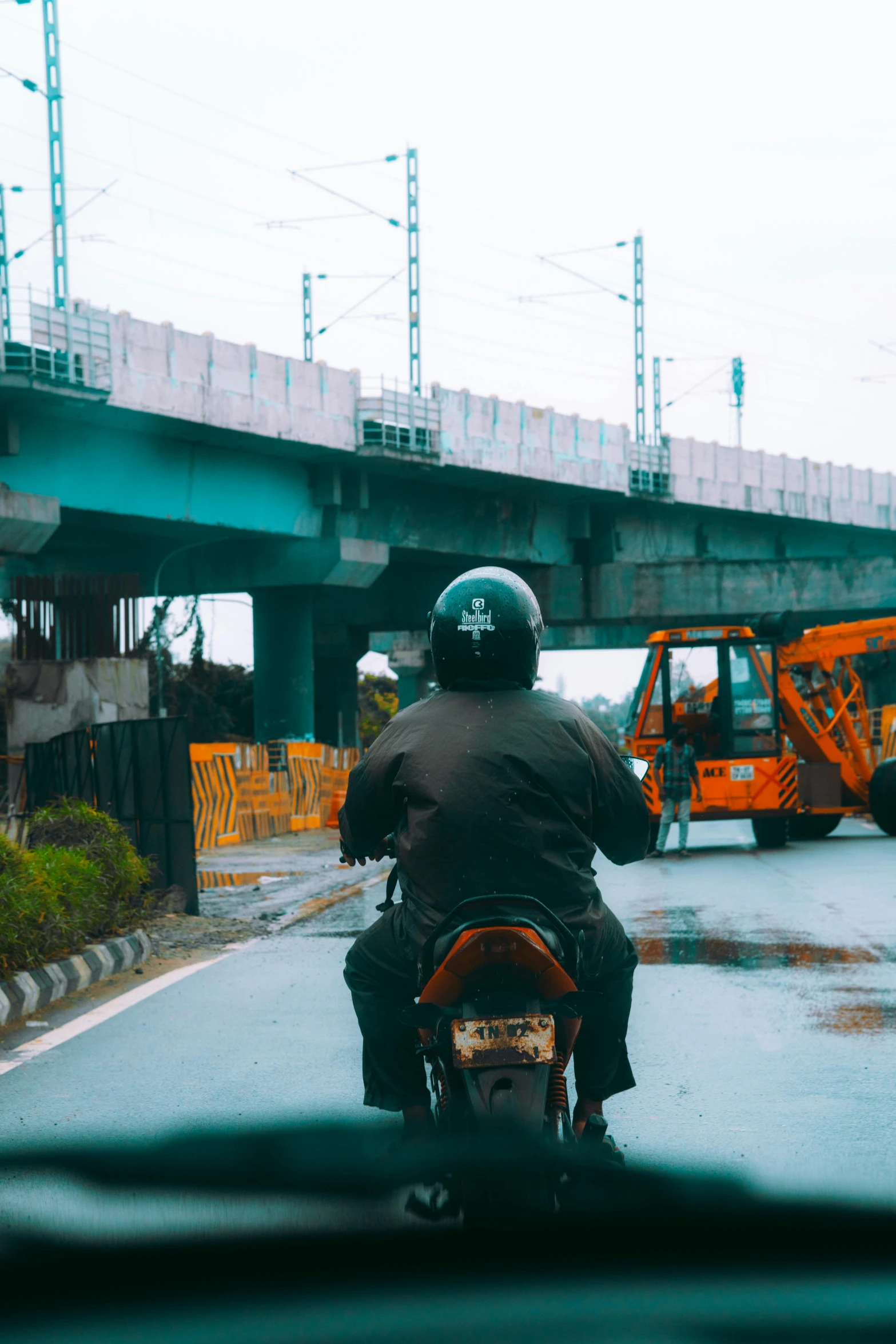 the rider is driving on the street on his motorcycle