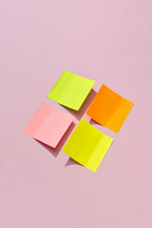 four pieces of paper placed in the shape of squares on a pink background