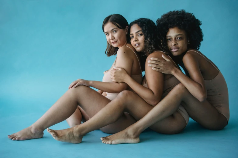 three women in identical outfits sitting on the ground