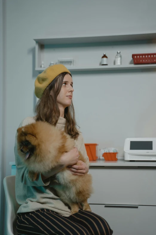 a person sitting in front of a microwave while holding a dog