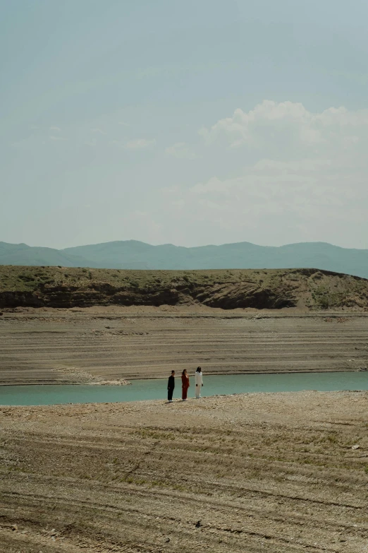 a couple of people standing in a field with a kite