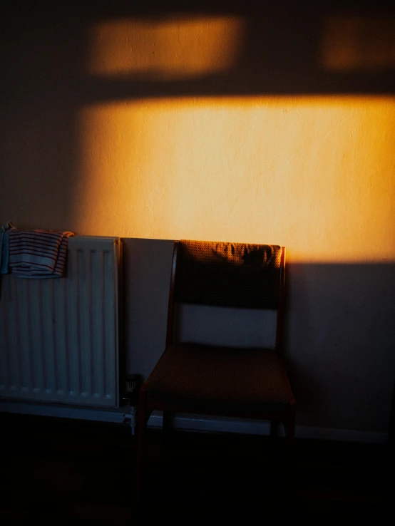 the chair is next to a small radiator and a window