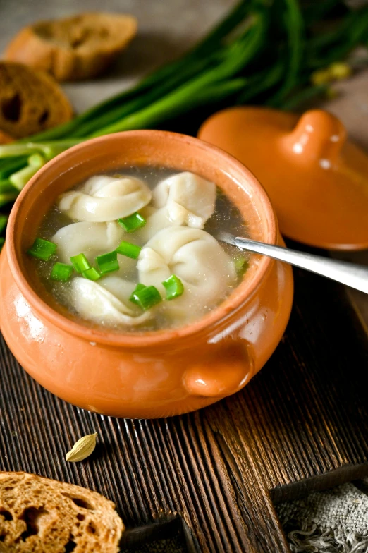 a bowl of ravioli soup, some green asparagus and a cookie