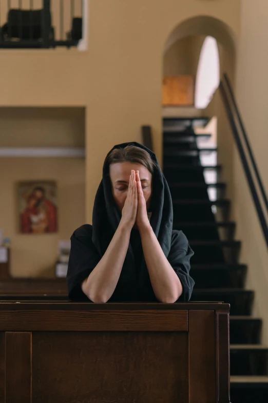 a girl with her hands in her ears, praying