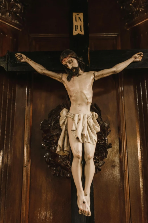 a crucifix with jesus statue displayed on top of a door