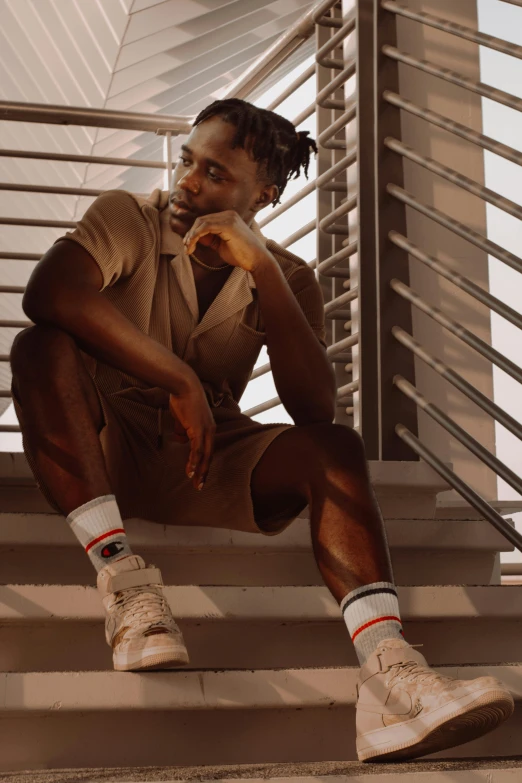 a man sitting down and leaning on the side of a stair rail