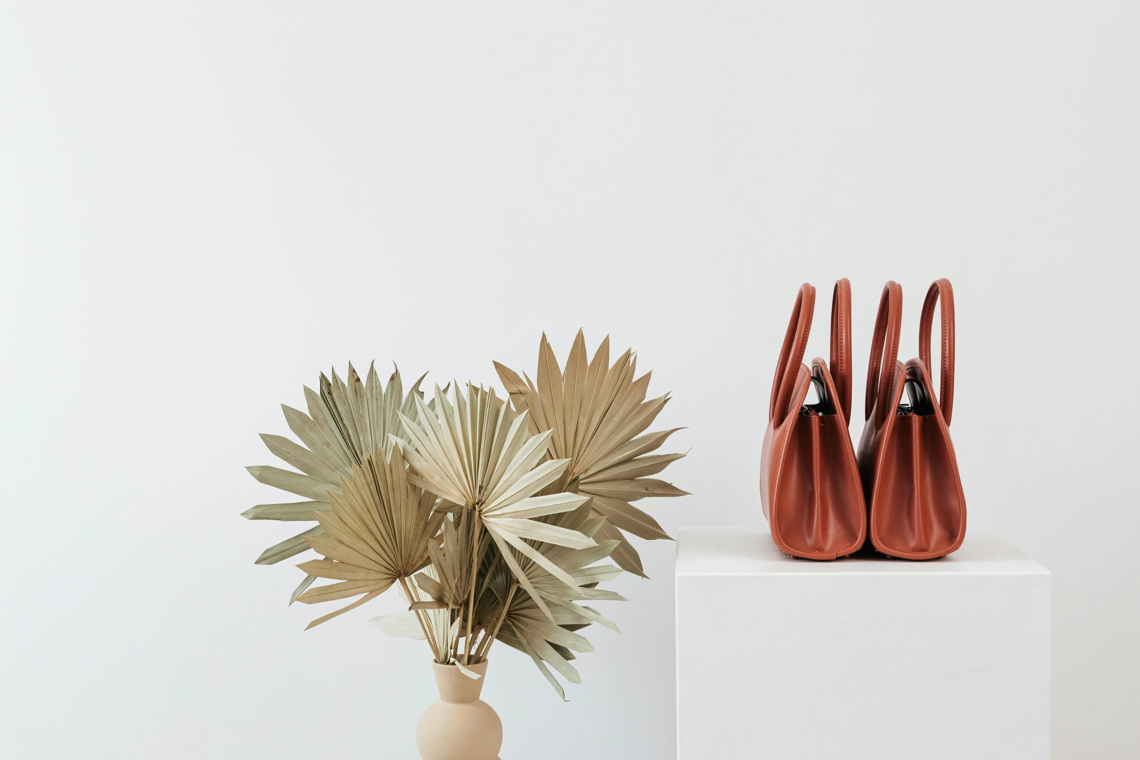 two small vases sitting on top of a white stand