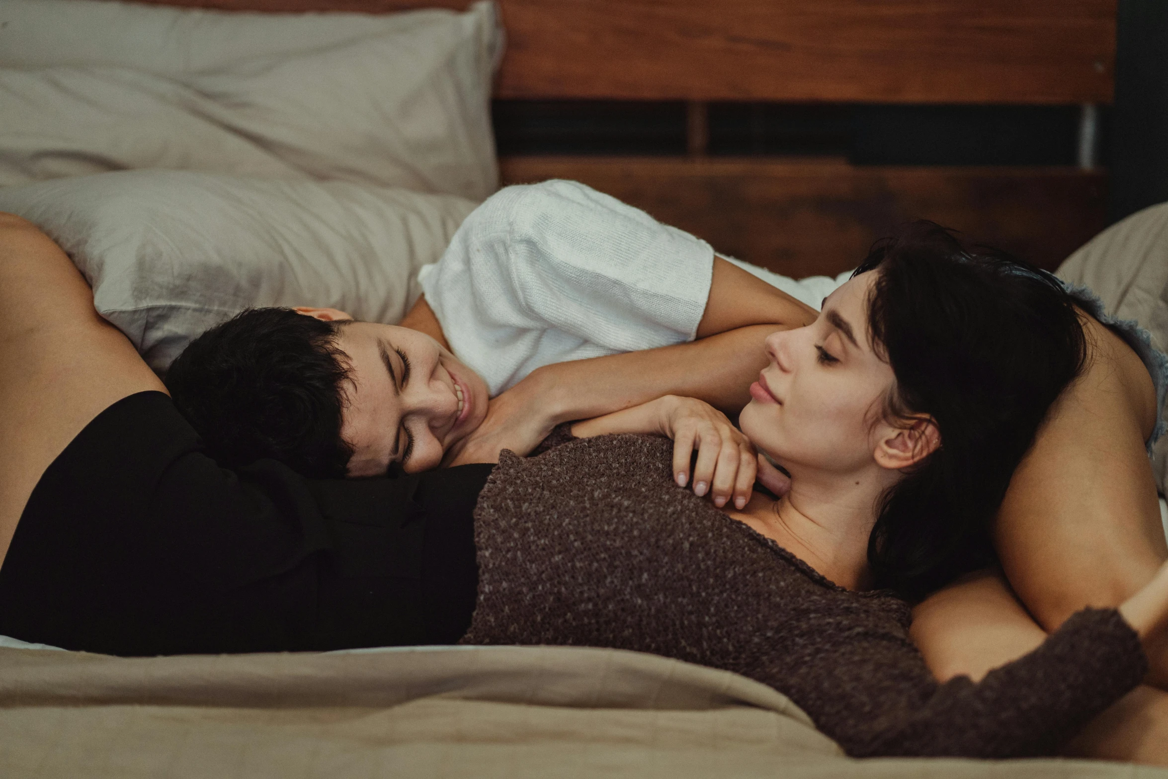 a man and woman are laying on a bed together