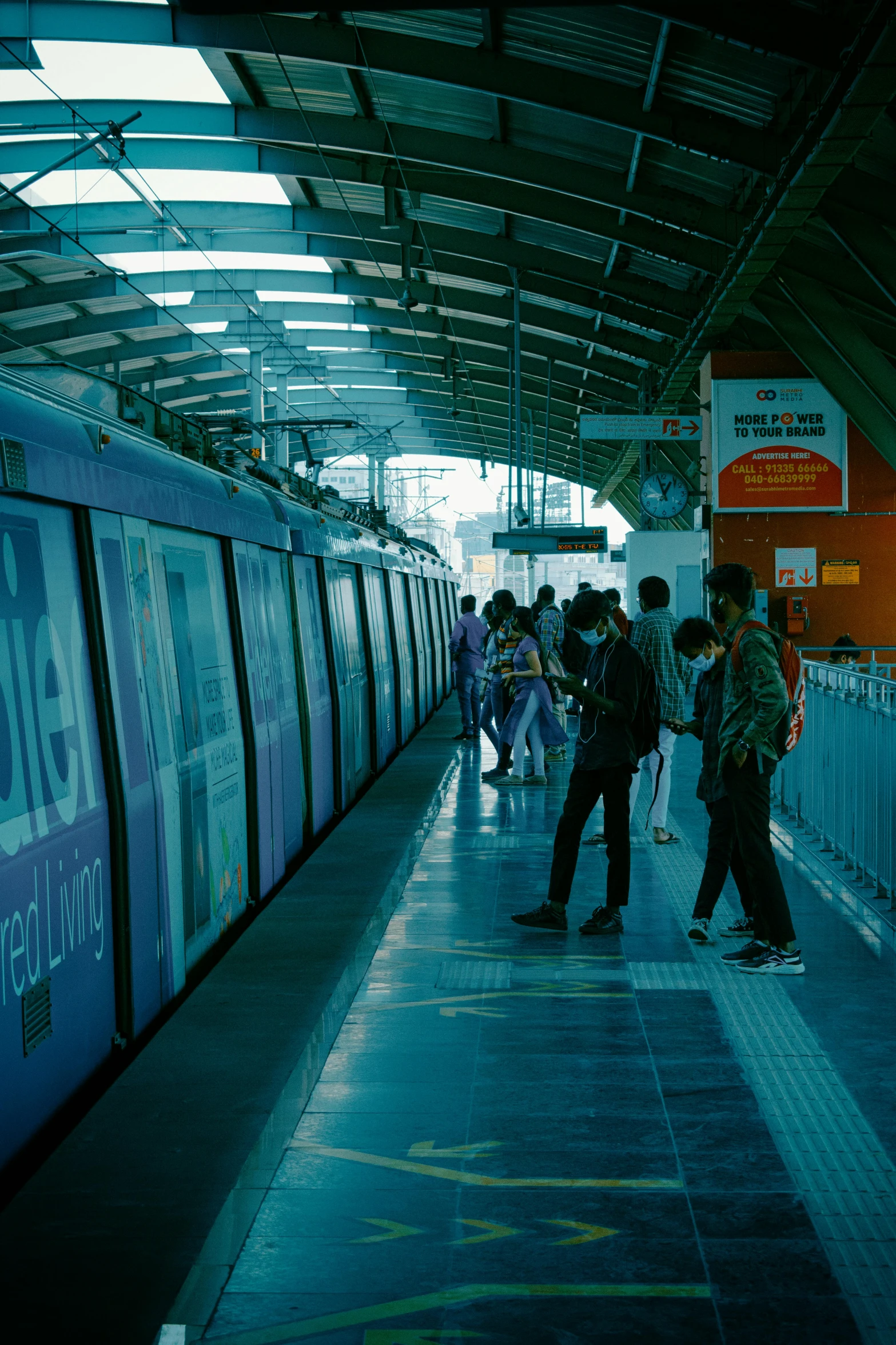 a group of people stand around waiting for the train to stop