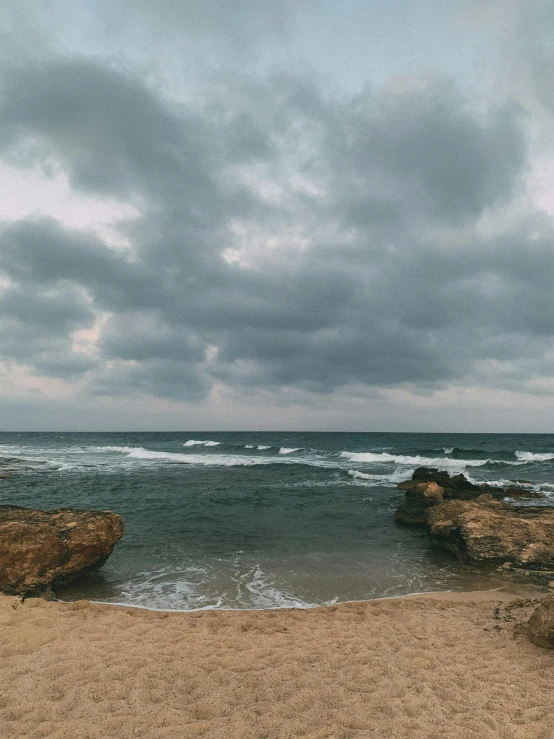 beach scene with ocean waves crashing on the shore and dramatic stormy sky