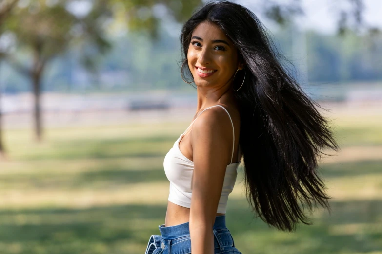 a woman is standing in the grass and smiling