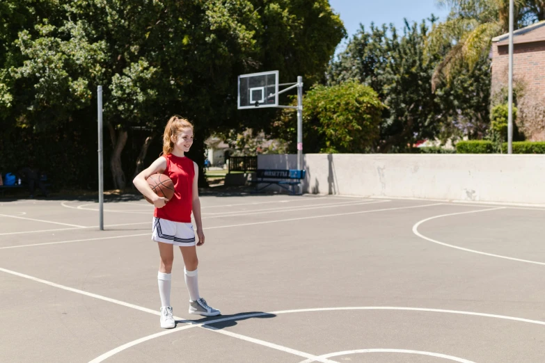 a female athlete is posing on a basketball court