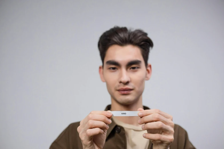 a young man holding an iphone in front of his face