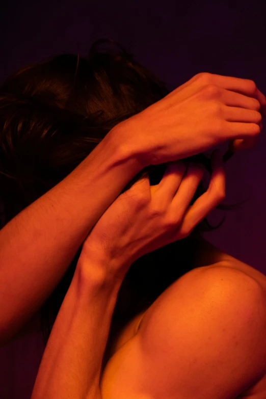 a close up s of a woman covering her face with her hands