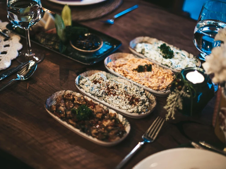 several dishes of food are lined up on the dining table