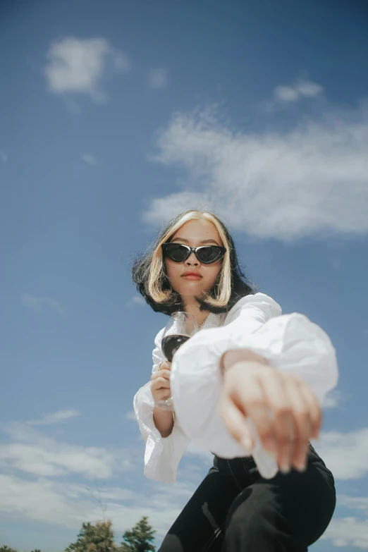 a woman with sunglasses on and a white shirt