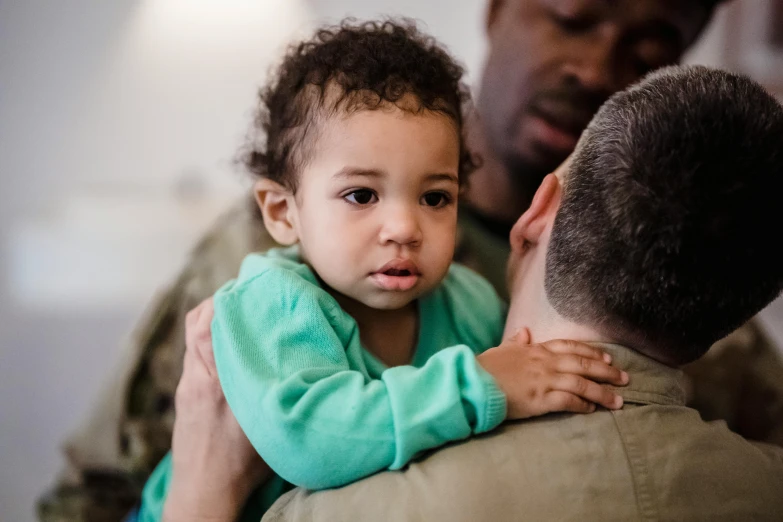 a man holds his daughter up and looks at her