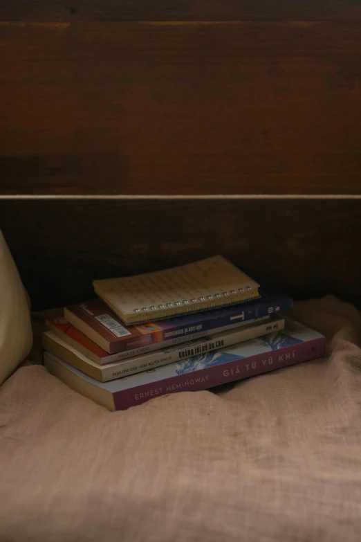 a stack of books sitting on top of a bed