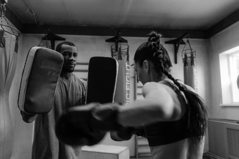 black and white po of two people practicing boxing