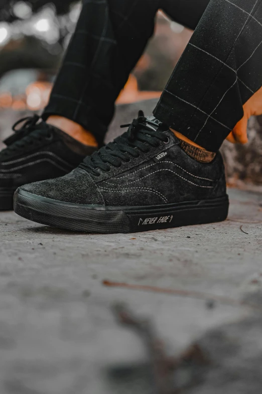 a person standing on top of a brick ground wearing black sneakers