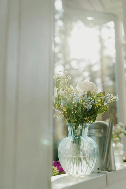 a vase filled with flowers next to a mirror