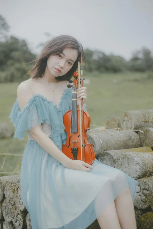 a girl holding onto a violin and posing for a po