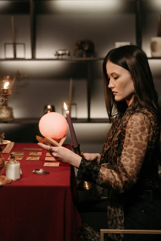 a woman setting up a table with decorative objects on it