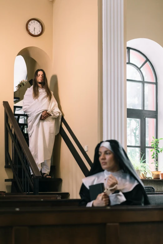 two women in robes at the bottom of stairs