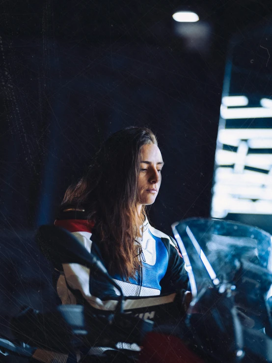 woman sitting on a motorcycle in a dark garage