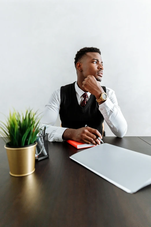 a man sitting at a desk with a laptop computer