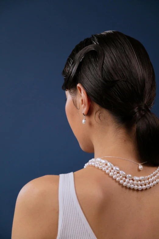 a close up view of a woman wearing a pearl necklace