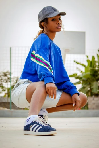 a girl is sitting on a skateboard and wearing a blue jacket